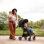 Μαύρο καρότσι μωρού με δύο παιδιά, για βόλτες.